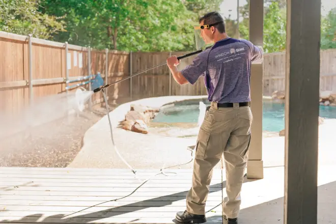 Window Genie professional cleaning a wooden fence.