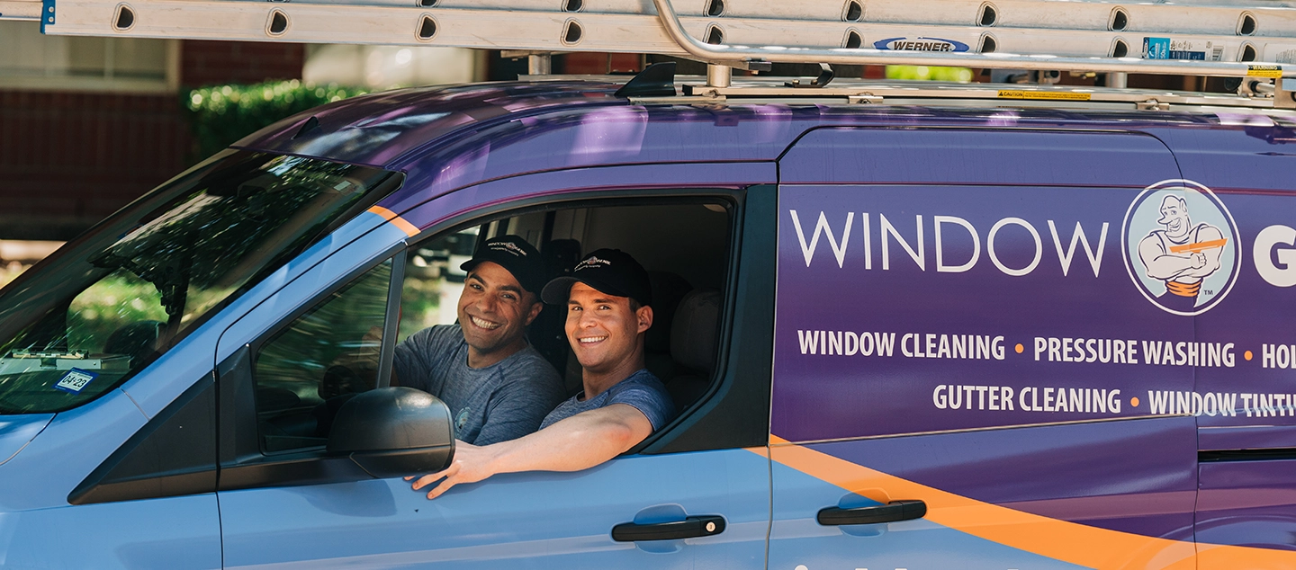 Customer speaking with Window Genie service professional in front of floor-to-ceiling windows.