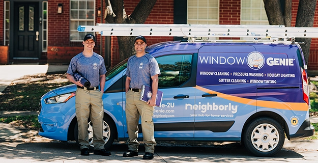 Two Window Genie professionals standing in front of van.