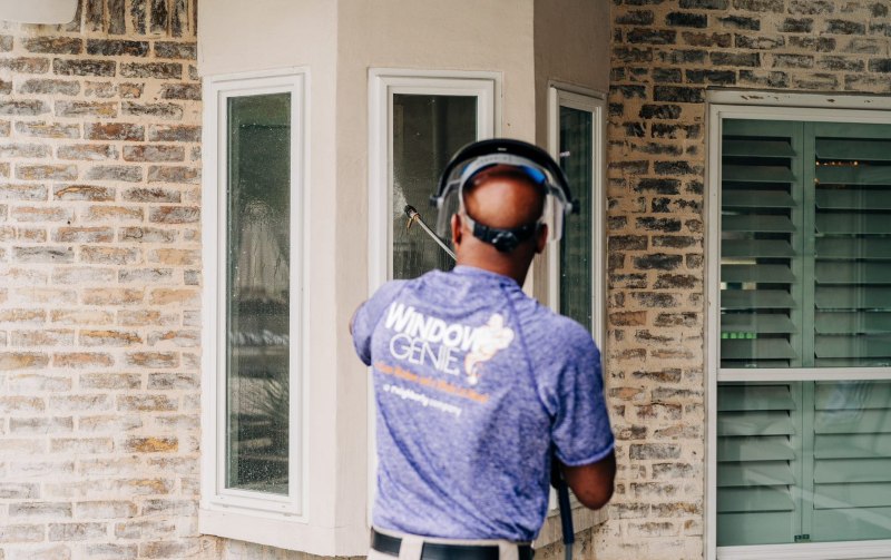 Window Genie Tech pressure washing a house in Oshkosh, WI