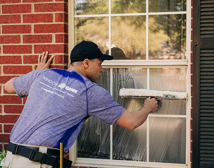 Window Genie technician outside performing residential window cleaning