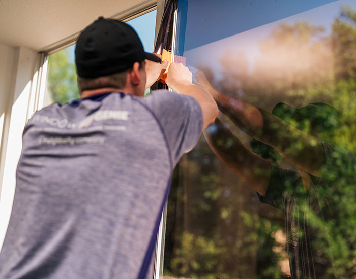 Window Genie technician measuring a window before applying solar control window film 