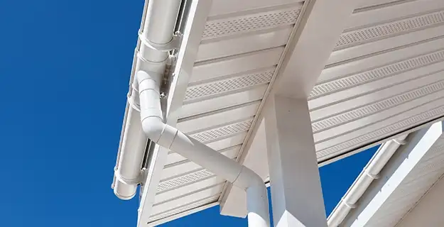 White gutters and large white eaves of a commercial building's roof.