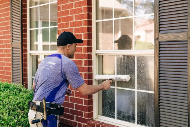 Window Genie service professional cleaning a window. 