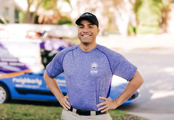 Smiling Window Genie tech outside ready to provide window cleaning services