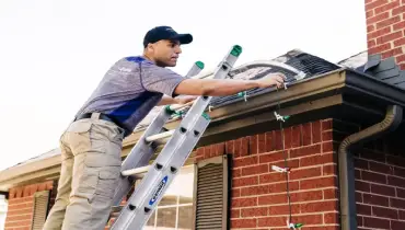 A Window Genie professional hanging christmas lights.